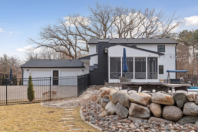 back of house with a lawn, fence, and a sunroom