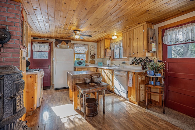 kitchen with light countertops, a healthy amount of sunlight, light wood-style flooring, and white appliances