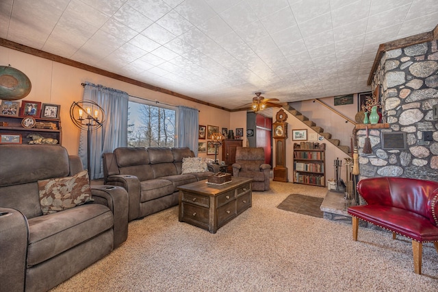 carpeted living area featuring stairs, crown molding, and a ceiling fan