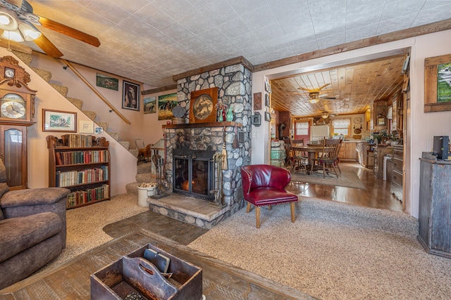 living area featuring a fireplace, wood finished floors, stairway, and a ceiling fan