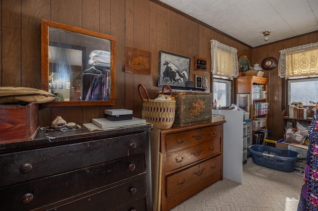 bedroom with ornamental molding, wood walls, multiple windows, and light colored carpet