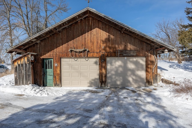 snow covered garage featuring a garage