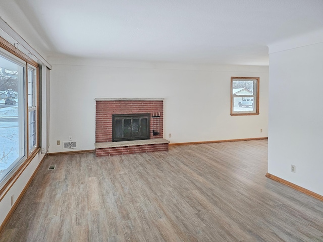 unfurnished living room featuring a fireplace and light hardwood / wood-style floors