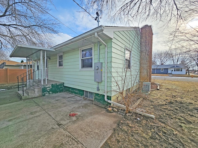 view of side of home with a patio and central air condition unit