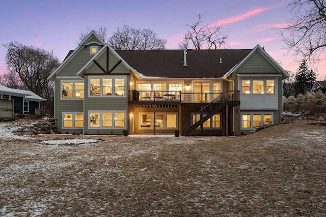 back house at dusk featuring a deck