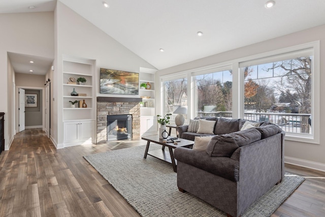 living room with a stone fireplace, dark hardwood / wood-style floors, built in features, and high vaulted ceiling