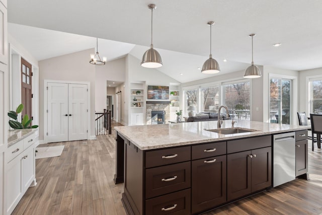 kitchen with pendant lighting, dishwasher, sink, and hardwood / wood-style flooring