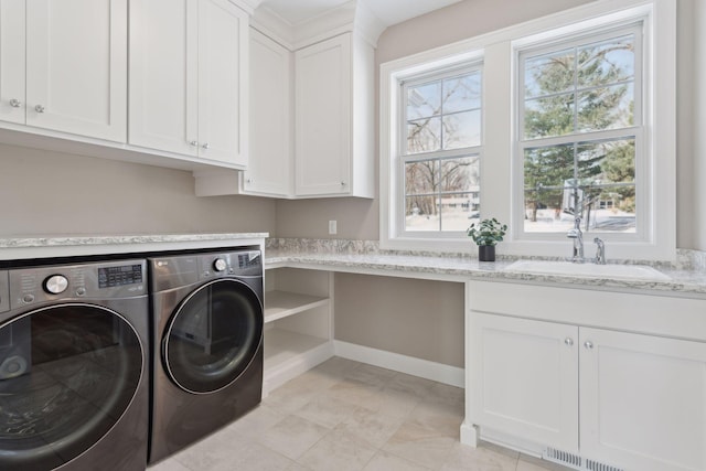 washroom featuring sink, washer and clothes dryer, and cabinets