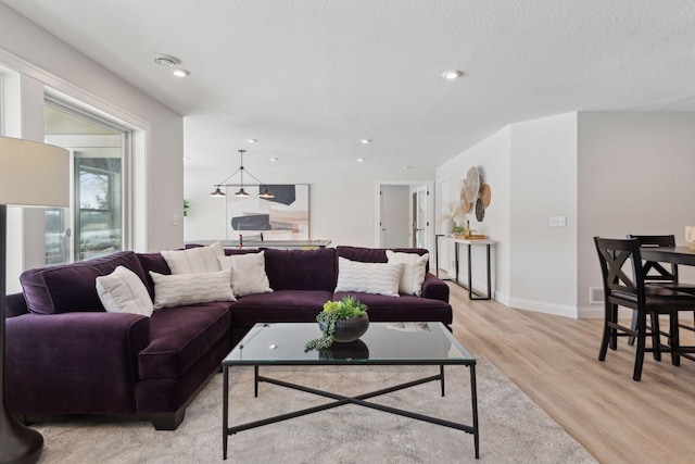 living room with light hardwood / wood-style floors and a textured ceiling