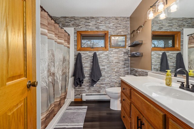 1378 Larrup Trl SW, Pine River, MN 56474 - bathroom featuring a baseboard radiator, vanity, toilet, wood finished floors, and a shower with shower curtain