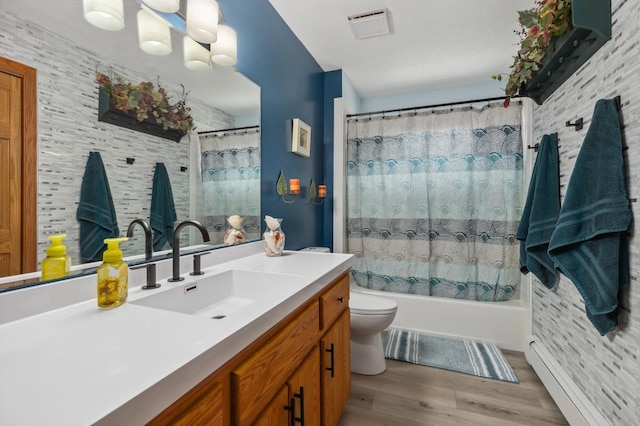 1378 Larrup Trl SW, Pine River, MN 56474 - bathroom featuring vanity, toilet, a baseboard radiator, wood finished floors, and shower / tub combo