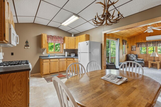 1378 Larrup Trl SW, Pine River, MN 56474 - dining room featuring vaulted ceiling, an AC wall unit, wood walls, ceiling fan, and baseboards
