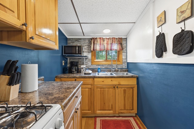 1378 Larrup Trl SW, Pine River, MN 56474 - kitchen with a sink, range, stainless steel microwave, dark countertops, and brown cabinetry