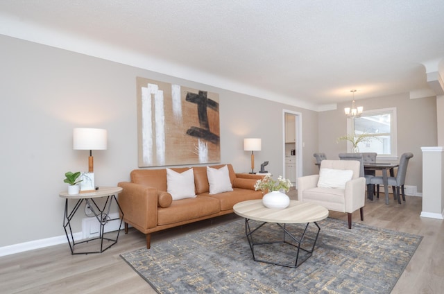 living room with wood-type flooring, a textured ceiling, and a notable chandelier