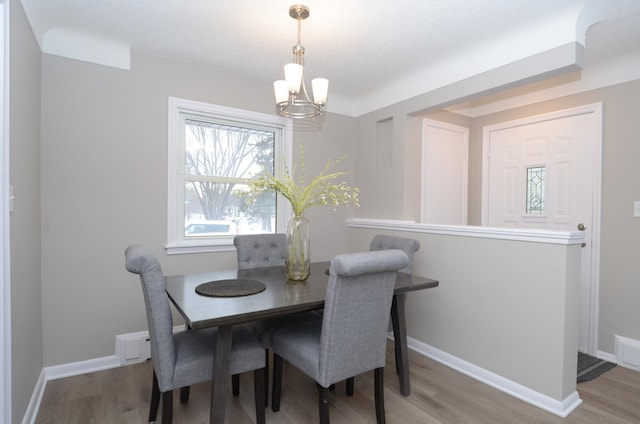 dining space with an inviting chandelier and hardwood / wood-style flooring