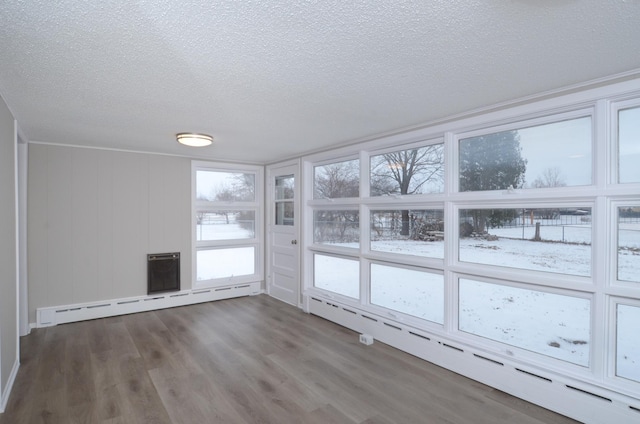 spare room with dark hardwood / wood-style flooring, a textured ceiling, and baseboard heating