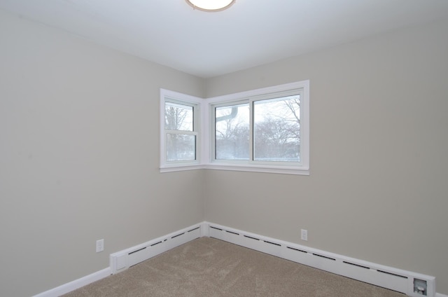 spare room featuring a baseboard radiator and carpet flooring