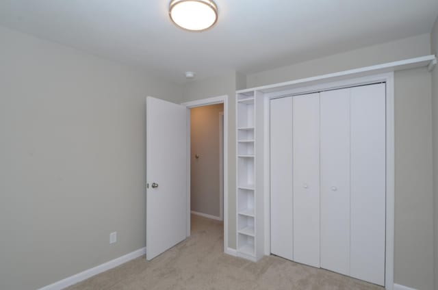 unfurnished bedroom featuring a closet and light carpet