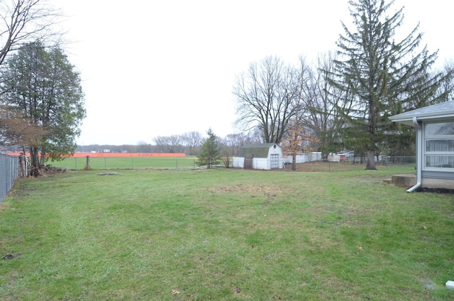 view of yard featuring a storage unit, an outdoor structure, and a fenced backyard