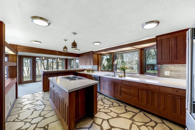 kitchen featuring a healthy amount of sunlight, tasteful backsplash, stainless steel appliances, and light countertops