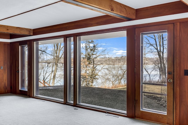 doorway to outside featuring beam ceiling, carpet flooring, and visible vents