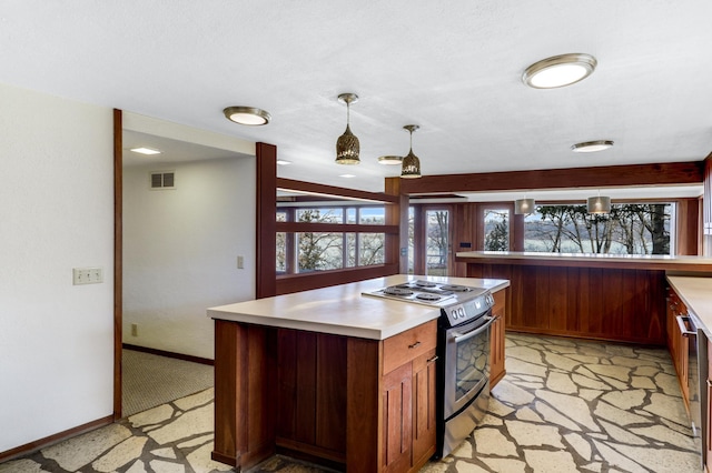 kitchen featuring visible vents, light countertops, stainless steel range with electric stovetop, and baseboards