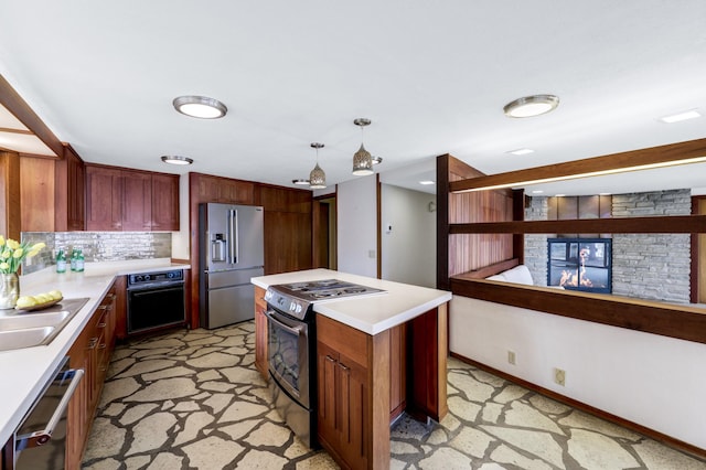 kitchen with pendant lighting, light countertops, appliances with stainless steel finishes, and tasteful backsplash