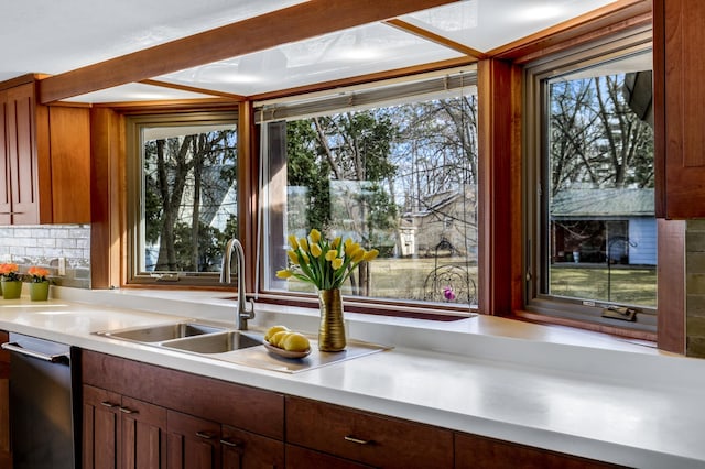 kitchen featuring a wealth of natural light, light countertops, and stainless steel dishwasher