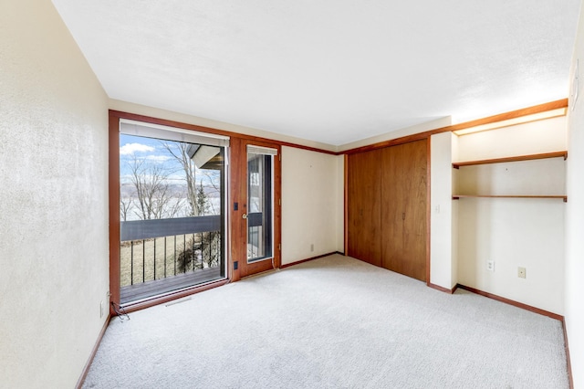 interior space featuring access to exterior, baseboards, visible vents, and light colored carpet