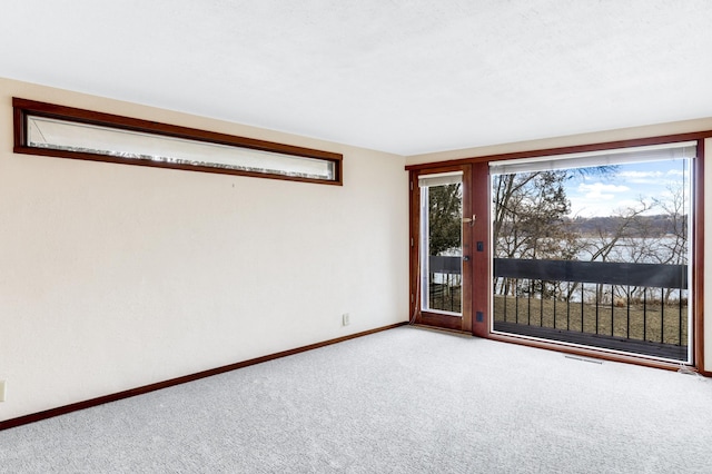 spare room featuring carpet and baseboards