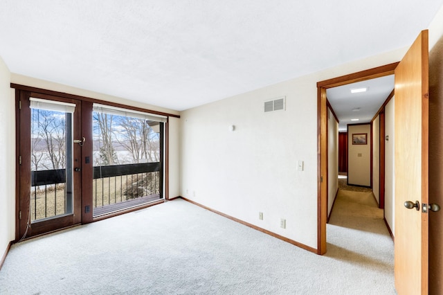 carpeted spare room with baseboards and visible vents