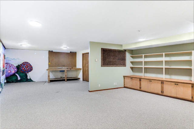 finished below grade area featuring light carpet and baseboards