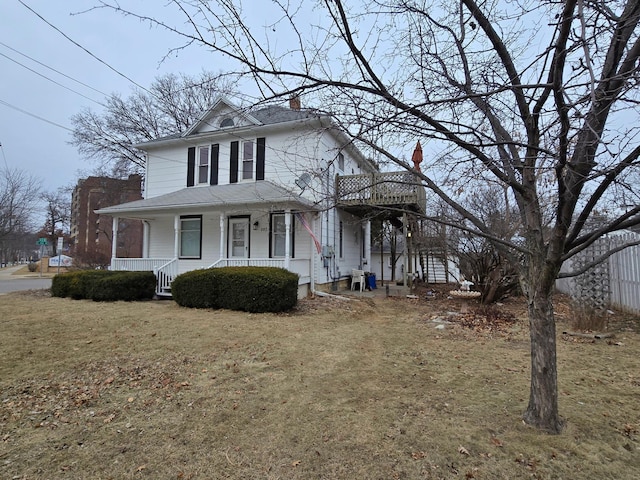 farmhouse featuring a porch and a front lawn