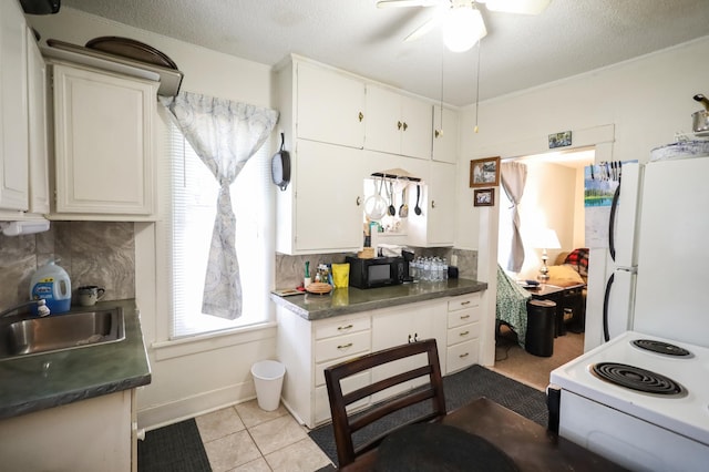 kitchen featuring light tile patterned flooring, sink, a textured ceiling, white appliances, and white cabinets