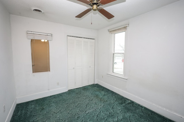 unfurnished bedroom featuring dark carpet, a closet, and ceiling fan