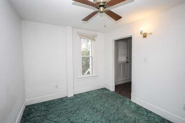 unfurnished room featuring ceiling fan and dark carpet