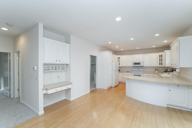 kitchen featuring white appliances, light hardwood / wood-style flooring, sink, white cabinetry, and kitchen peninsula