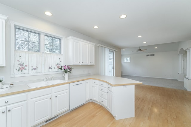 kitchen featuring sink, dishwasher, white cabinetry, and kitchen peninsula