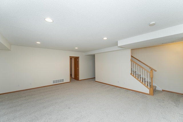 basement featuring carpet floors and a textured ceiling