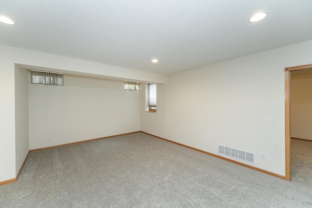 basement featuring a textured ceiling and carpet flooring