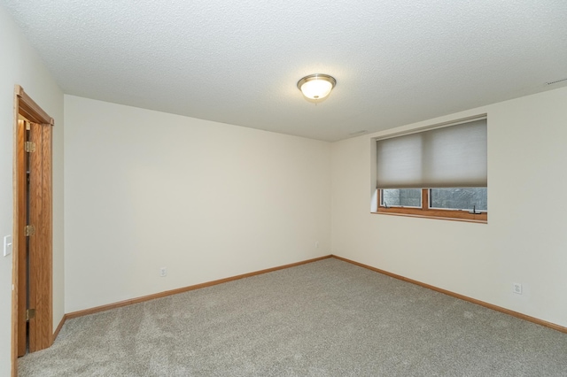 spare room featuring carpet flooring and a textured ceiling