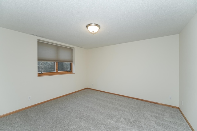 carpeted spare room with a textured ceiling