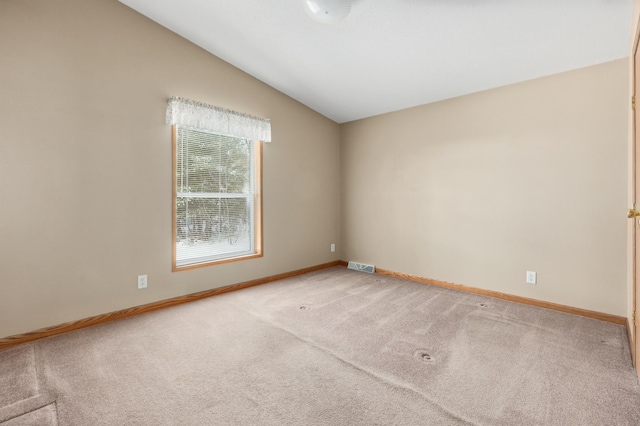 carpeted empty room featuring lofted ceiling