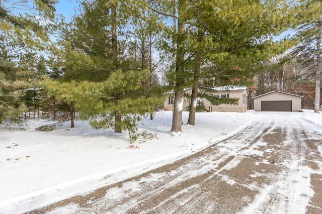 snowy yard featuring a garage