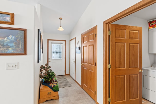 interior space featuring vaulted ceiling, washer / clothes dryer, and light floors