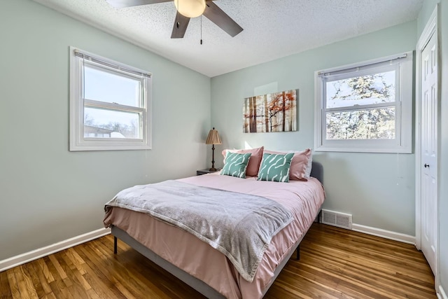 bedroom with hardwood / wood-style flooring, ceiling fan, a textured ceiling, and a closet