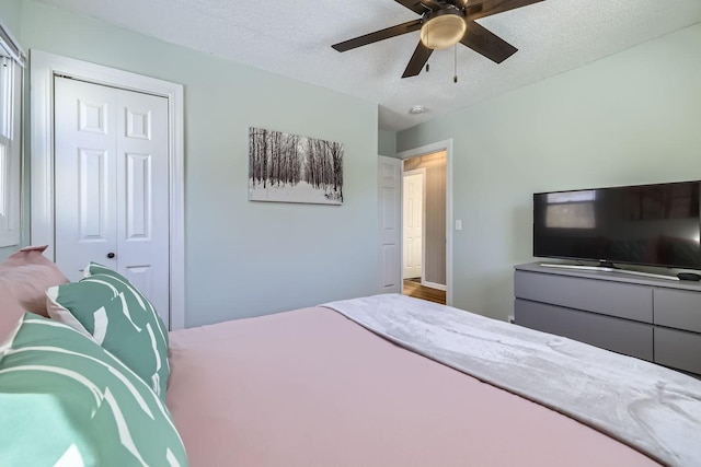 bedroom featuring ceiling fan, a closet, and a textured ceiling