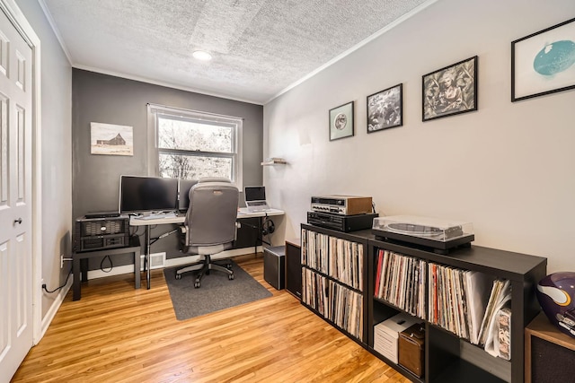 home office with ornamental molding, hardwood / wood-style floors, and a textured ceiling