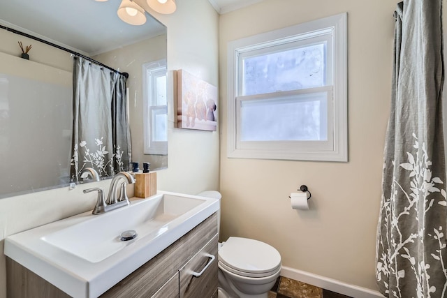 bathroom featuring vanity, toilet, a shower with shower curtain, and a wealth of natural light