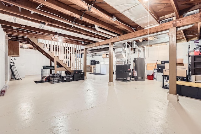 basement featuring independent washer and dryer, heating unit, and gas water heater